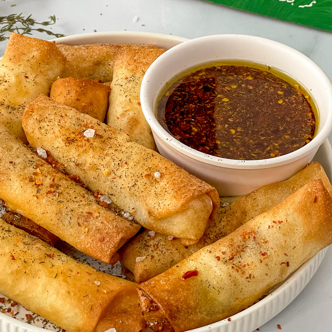 Golden-brown Date Feta Rolls served with a spicy honey sauce, featuring Large Medjool Dates, feta cheese, and crispy spring roll wrappers.