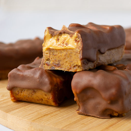 Homemade Medjool Date Snickers Bars made with Linah Farms' Gazelle Medjool Dates, peanut butter, roasted peanuts, and melted chocolate.