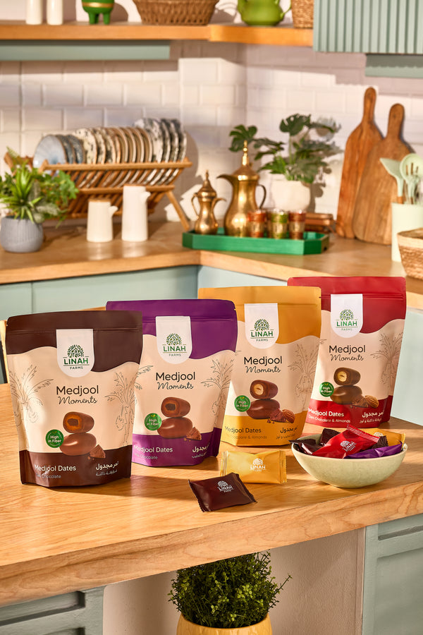 Full range of Linah Farms Medjool Moments Chocolate Medjool Dates in Resealable Pouches on Kitchen Counter