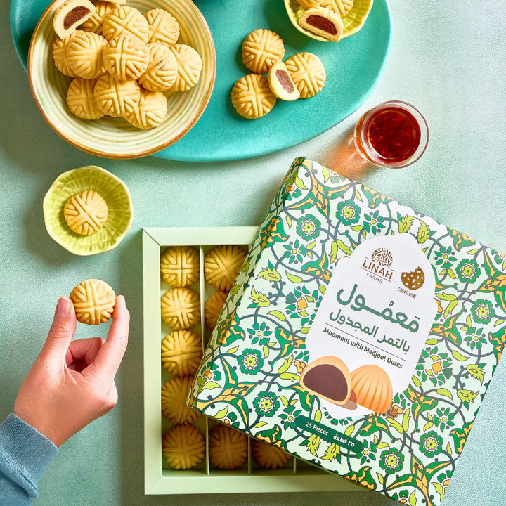 A golden box of Maamoul from Linah Farms in collaboration with The Cookievore, featuring beautifully arranged date-filled pastries.