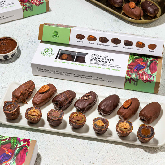 7-piece pack of Belgian chocolate-covered Medjool dates with assorted fillings: coffee, caramel, orange-cinnamon, peanut butter, almond, and Snickers displayed on a plate 