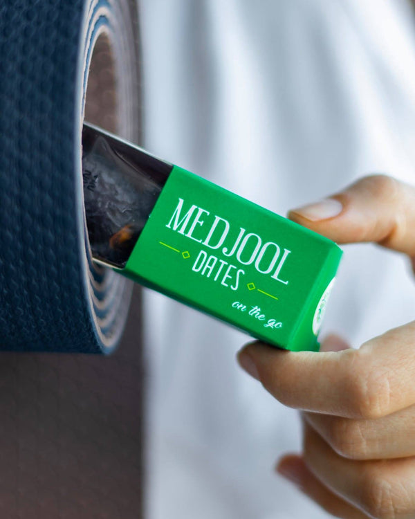 Linah Farms medjool dates on the go pack being pulled out of a yoga mat.